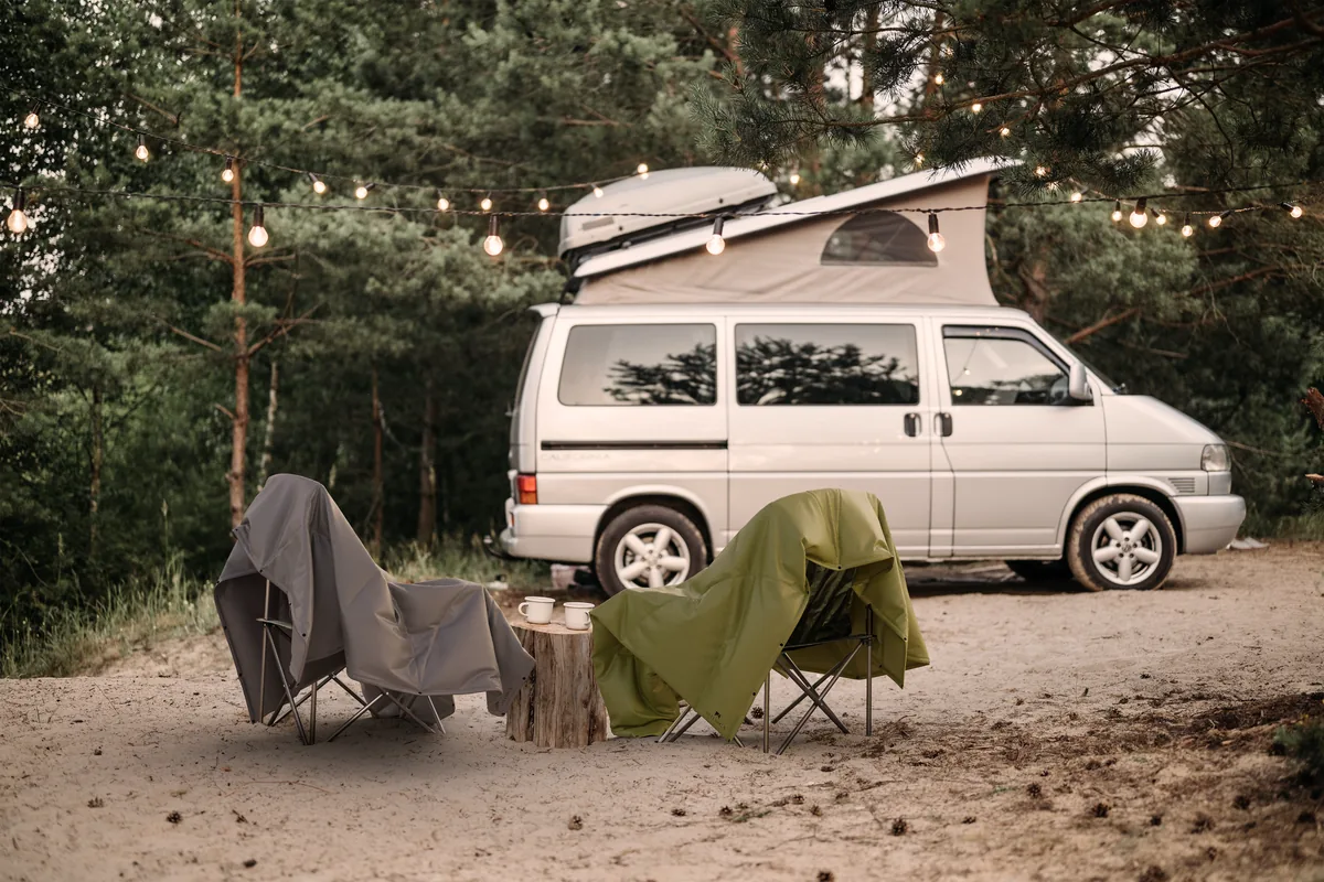 Artemica-Decken auf Campingstühlen vor VW-Bus